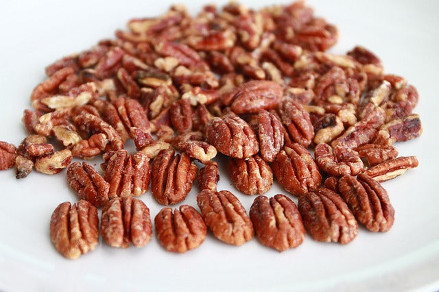 Spiced pecans lying on a white background